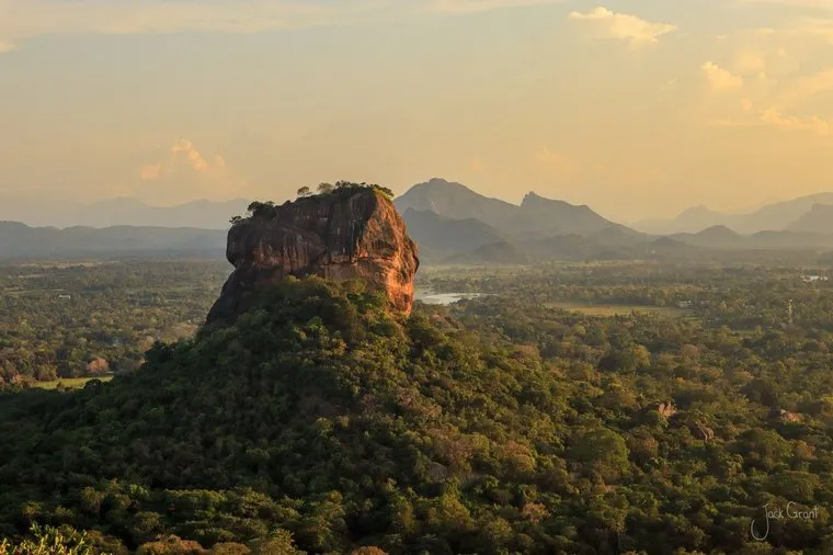 Sigiriya rock fortress rising above jungle at sunset, Sri Lanka